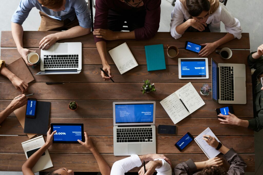 people working at a table full of laptops